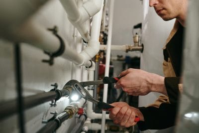 Technician inspecting commercial plumbing pipes in Mountain View